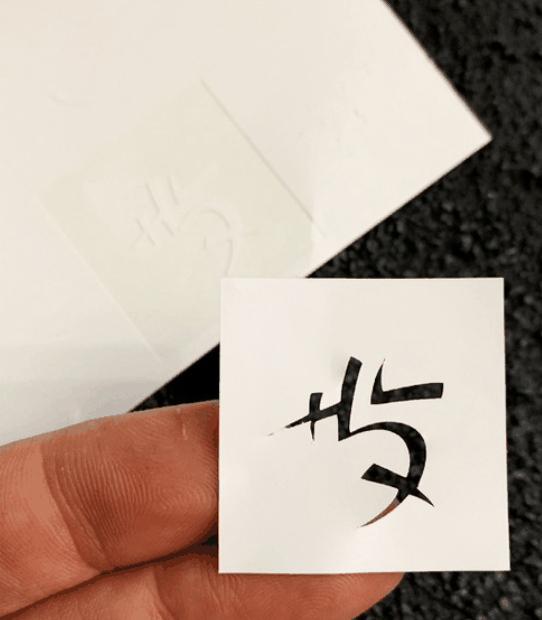 Self-adhesive vinyl stencil cutout on backing sheet
